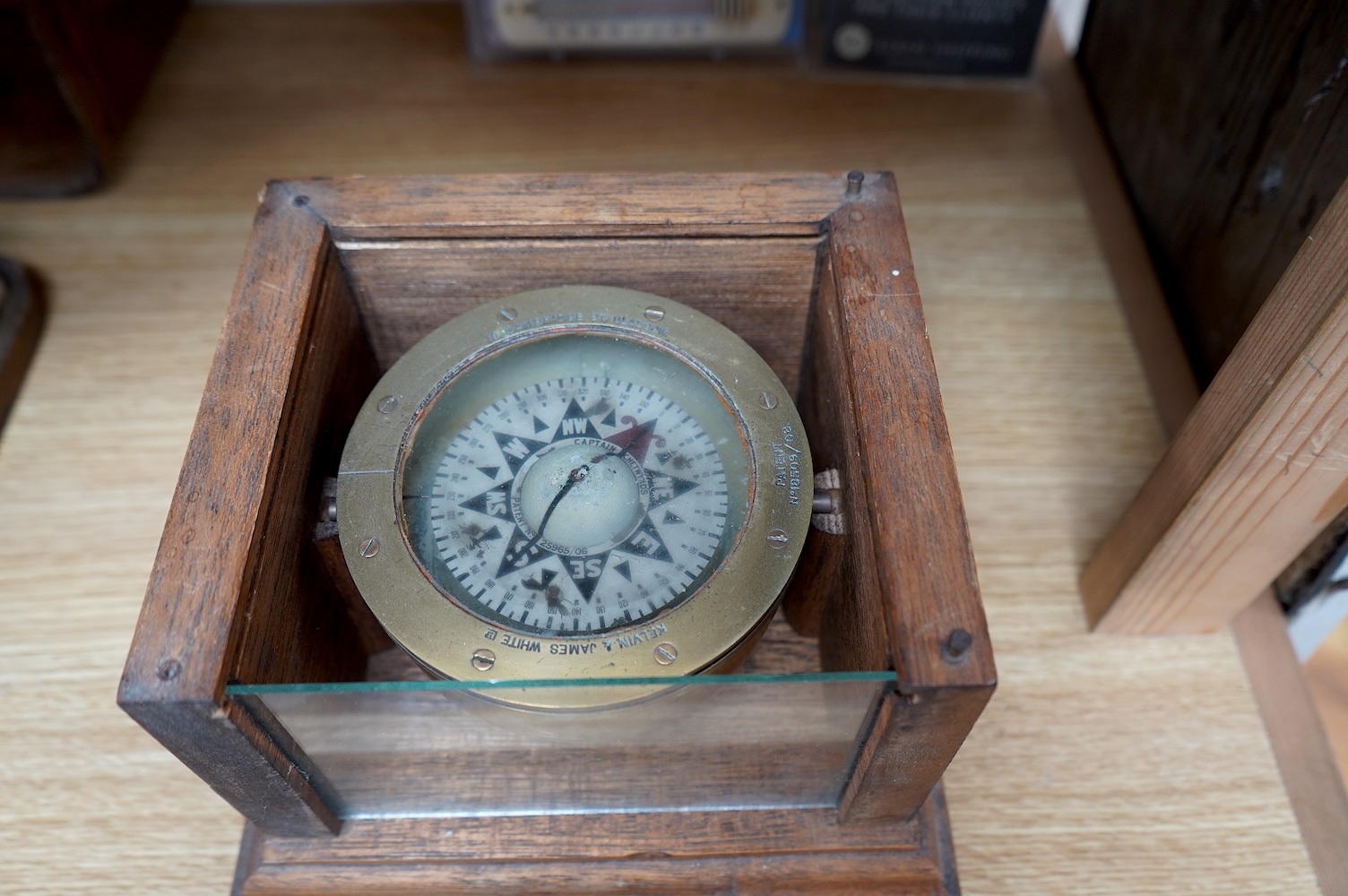 A ‘Kelvin & James White Ltd. 18 Cambridge St. Glasgow’ ship's compass, in a later oak case, 13cm high, 21cm wide, 19cm deep. Condition - poor to fair.